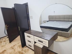1 dormitorio con cama y espejo en الجبيل, en Al Jubail
