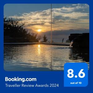 a sign that says travel review awards with a sunset in the water at Kaiyutei in Kawazu