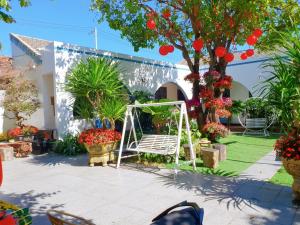 a garden with flowers and a white swing at Tropical Homestay Phu Yen in Tuy Hoa
