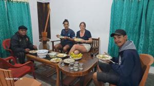 a group of people sitting around a table eating food at Wisma PO'ONG in Ruteng
