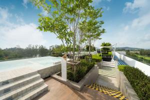 een zwembad met een boom op het dak van een huis bij Laguna BangTao Beach skypark Apartment in Phuket