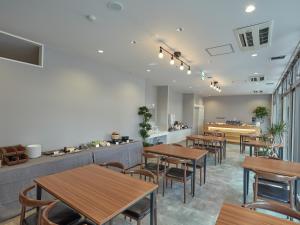 a restaurant with wooden tables and chairs and a counter at EZ HOTEL 関西空港 Seaside in Izumi-Sano