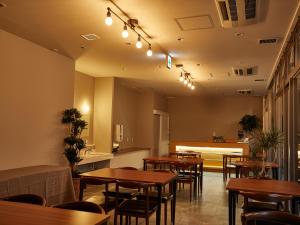 泉佐野的住宿－EZ HOTEL 関西空港 Seaside，餐厅设有木桌和椅子及灯