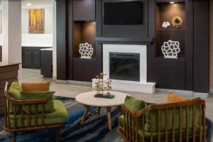 格爾夫波特的住宿－海灣港比洛克西費爾菲爾德套房酒店，客厅配有两把椅子和壁炉