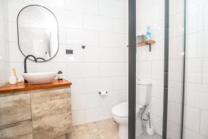 La salle de bains est pourvue de toilettes et d'un miroir. dans l'établissement Tropical Bliss in Woolner, à Stuart Park