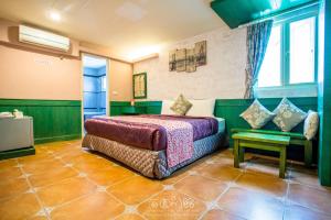 a bedroom with a bed and a table and a window at 墾丁海園別館Hai Yuan Inn in Kenting