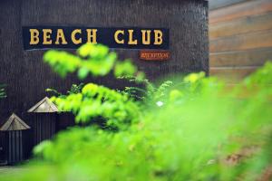 una señal de club de playa en el lateral de un edificio en Koh Tao Beach Club en Ko Tao