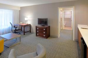 a hotel room with a television and a desk at Courtyard by Marriott Kokomo in Kokomo