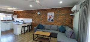un soggiorno con divano e muro di mattoni di Centrepoint Motel Deniliquin a Deniliquin
