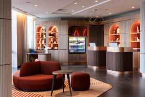 a restaurant with a red chair and a bar at AC Hotel Paris Porte Maillot by Marriott in Paris