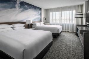 a hotel room with two beds and a large window at Newark Liberty International Airport Marriott in Newark +37 photos