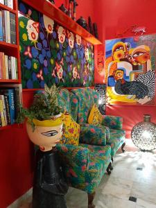 - un salon avec un canapé et une étagère à livres dans l'établissement The Coral House Homestay by the Taj, à Agra