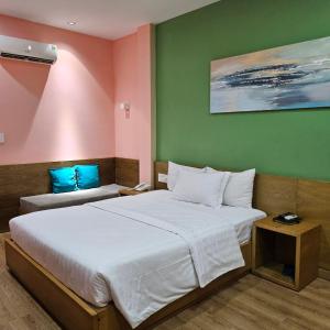 a bedroom with two beds and a green wall at A25 Hotel - 142 Bùi Thị Xuân in Ho Chi Minh City +32 photos