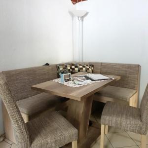 a wooden table with two chairs and a lamp at Ferienwohnung Sonnenschein Familie Hamdorf in Bad Sulza
