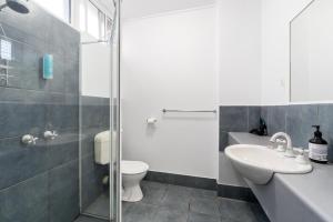 uma casa de banho com um WC, um lavatório e um chuveiro em Colac Central Motel em Colac