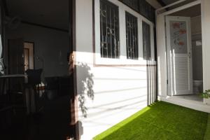 eine offene Tür zu einer Veranda mit grünem Gras in der Unterkunft 2B Cozy Hostel ตรัง in Trang