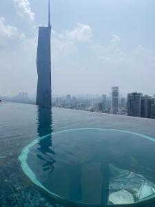 uma piscina de beiral infinito no telhado de um arranha-céus em Harmony Luxury Suites At Lucentia Bukit Bintang City Center em Kuala Lumpur