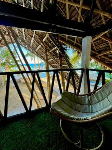 a curved chair in a building with a view of the beach at On Board Panglao Beach Hostel & Resort in Dao