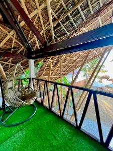 ダオにあるOn Board Panglao Beach Hostel & Resortの緑の床と大きな窓が備わる客室です。