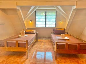 a room with two beds and a window at On Board Panglao Beach Hostel & Resort in Dao