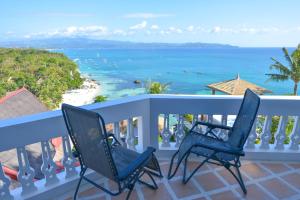 Duas cadeiras sentadas numa varanda com vista para o oceano em Tropicana Ocean Villas em Boracay