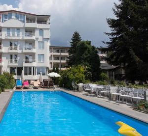 奧赫里德的住宿－喬丹別墅酒店，一座大型蓝色游泳池,位于大楼旁边