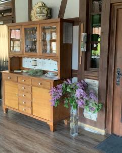 Landhotel Ruhepol - garni في آرنشتات: مزهرية مليئة بالورود الأرجوانية في الغرفة