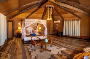 a bedroom with a bed and a table in a room at Souly Ecolodge Salalah in Salalah
