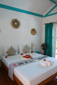 a bedroom with two beds with flowers on them at Casa Kapuas in Gili Trawangan