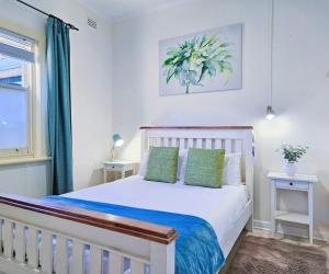 - une chambre avec un lit blanc et une fenêtre dans l'établissement Cozy Beach Cottage Steps from Beach Jetty, à Largs