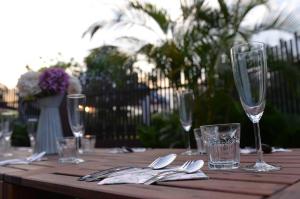 a wooden table with wine glasses and silverware on it at Yussy X Harvest 29 in Masai +17 photos