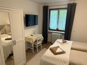 Zimmer mit 2 Betten, einem Tisch und einem Fenster in der Unterkunft Gästehaus Sandvoss in Titisee-Neustadt