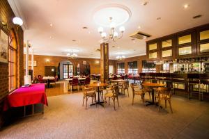 a restaurant with tables and chairs and a bar at Albury Paddlesteamer Motel in Albury