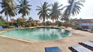 a large swimming pool with palm trees in a resort at Safari Village - Case73 in Saly Portudal