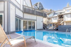 a house with a swimming pool in front of a building at Cross Creek - Pool and Hot Tubs by Daniel in Frisco