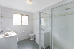 ein weißes Badezimmer mit Dusche und Toilette in der Unterkunft Blue Waters Apartments in Eden + 9 Fotos