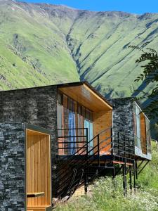 a house with a deck and mountains in the background at Ardoti Guest House in Ardoti
