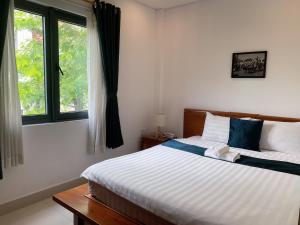 1 dormitorio con cama y ventana en Twins Hotel, en Ho Chi Minh