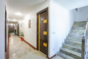 pasillo con escaleras y puerta de madera en FabHotel BR International en Agra