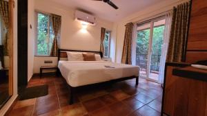 sypialnia z łóżkiem i dużym oknem w obiekcie Forest Escapes Koyna w mieście Koynanagar