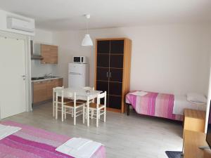 a room with a kitchen and a table and a bed at Duna camere con bagno in Lido Adriano