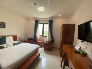 1 dormitorio con 1 cama grande y TV en Twins Hotel, en Ho Chi Minh