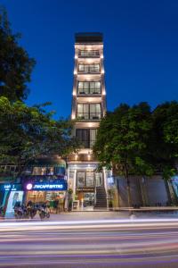 un edificio alto por la noche con una calle delante en Avani Central Hotel, en Hanói
