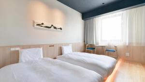 a bedroom with two white beds and a window at Vessel Hotel Campana Susukino in Sapporo
