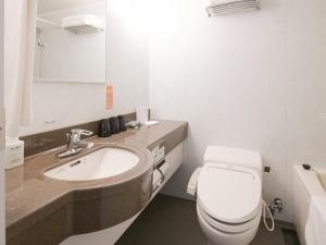 een badkamer met een wit toilet en een wastafel bij Vessel Inn Sapporo Nakajima Park in Sapporo