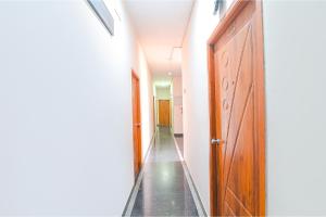 an empty corridor with a wooden door and a hallway at FabHotel VRJ Residency in Chennai