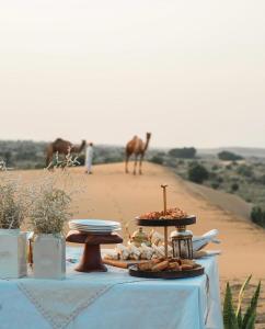 een tafel met eten in de woestijn bij Mughal Sam Sand Dunes Desert Safari in Sām