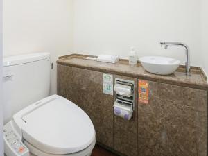 Łazienka z białą toaletą i umywalką w obiekcie Vessel Inn Sapporo Nakajima Park w mieście Sapporo