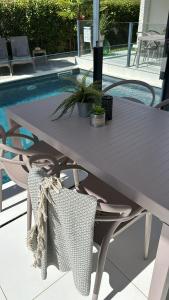 - une table de pique-nique avec 2 chaises et une piscine dans l'établissement First apartment Zadar, à Zadar