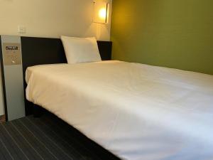 1 cama blanca grande en una habitación de hotel en Sanco Inn Nagoya Fushimi, en Nagoya